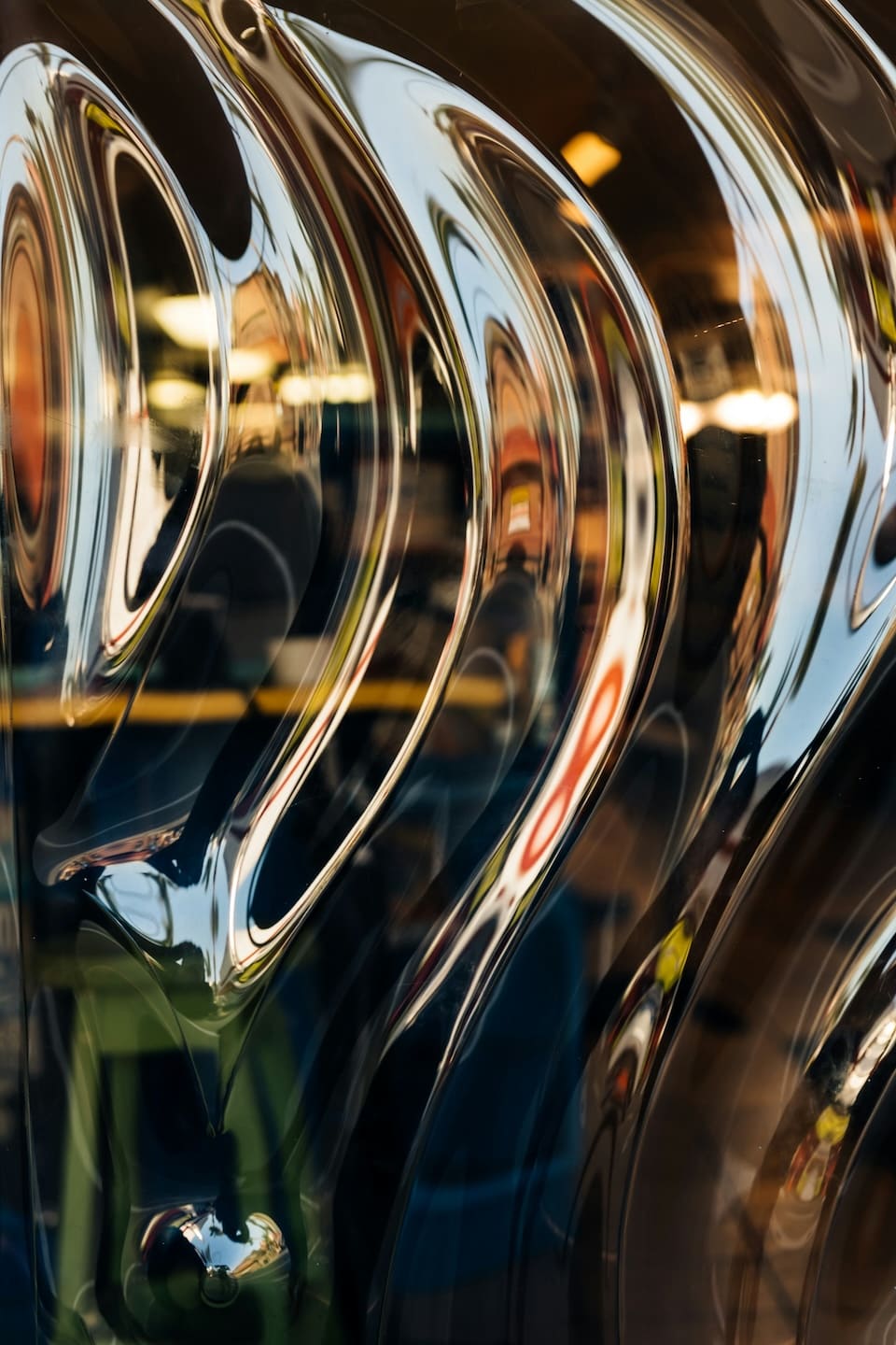 Curved reflective metal surfaces catch warm light.