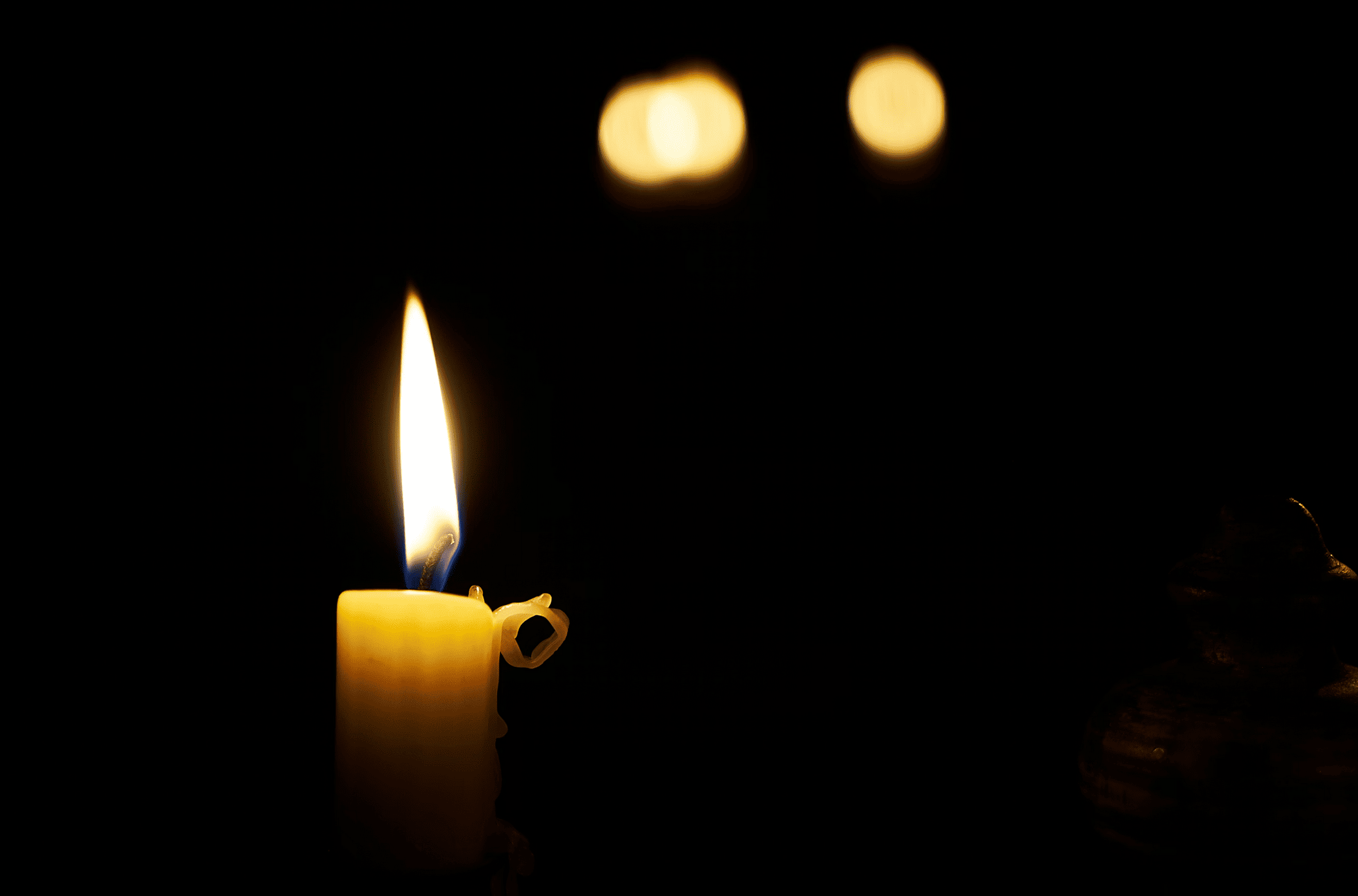 A candle burns in a dark room.